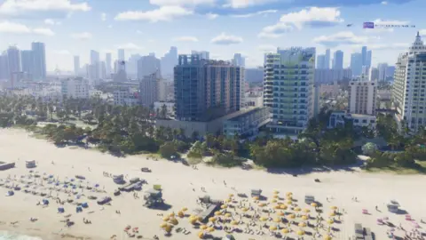 Rockstar Games A screenshot from GTA 6 shows a wide, elevated shot of a sun-kissed beach crowded with rows of sun loungers and yellow parasols with lifeguard stations inbetween them. A row of skyscrapers lines the edge of the sand and blends into a cityscape as far as the eye can see.