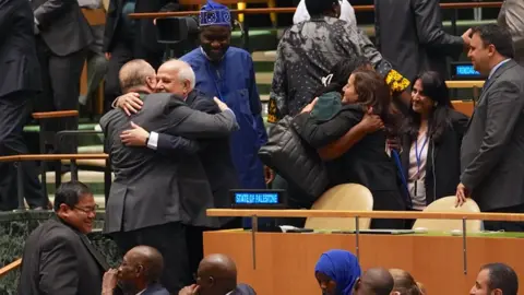 Palestinian diplomats celebrate after the UN General Assembly endorses a resolution demanding Israel end "its unlawful presence in the Occupied Palestinian Territory" within 12 months, at UN headquarters in New York (18 September 2024)