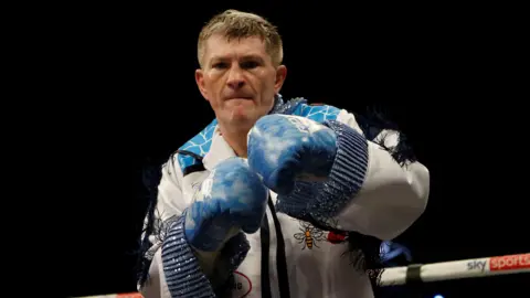 Reuters Ricky Hatton stood in his boxing gear, including blue gloves, warms up in the ring