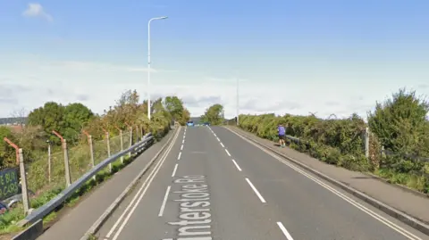 Google maps street view of Winterstoke Road in Weston-super-Mare. It is a straight, single carriageway. There is a pavement either side of the road.