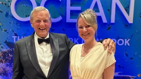 Sussex Underwater Sussex Underwater co-founders Eric Smith and Catrine Priestly at the premiere of Ocean in London. Eric is wearing a black tuxedo and Catrine is wearing a pale yellow dress.