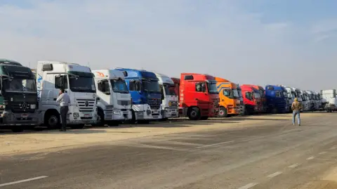 Reuters Aid trucks parked in Al-Arish near the Egyptian border with Gaza (January 16, 2025)