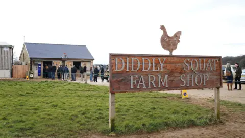 PA Media is an external image of Diddly Squat Farm Shop, with people's lines to enter the store