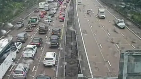 Traffic builds up on one side of a duel carriageway. On the other side, vehicles drive freely