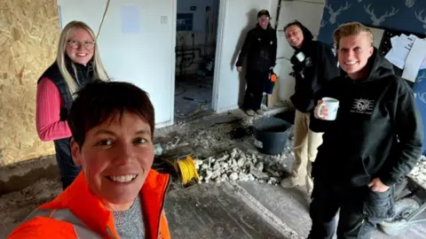 Fiona Parsons (in orange jacket) and Kat Parsons (holding a cup) on the construction site