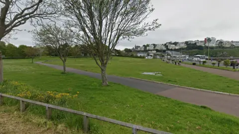 Google Maps Green grass and trees in Torquay's Abbey Park and Meadows with Torquay seafront in the background.