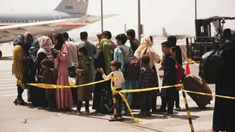 Reuters Civilians queuing for a plane at Kabul airport