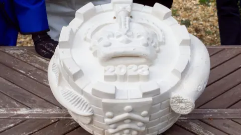 The King’s Foundation Stone, round statue of a pie with a lamprey circling around it and '2023' on the front of it.