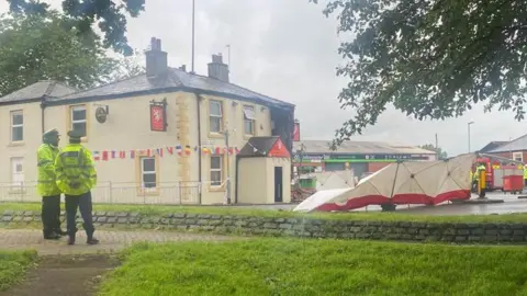 Police look on at the cordoned off White Lion pub