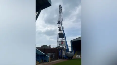BBC / Paul Newton Huge cherry-picker type crane preparing to dismantle the floodlight pylon