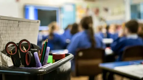 A picture of a class full of schoolchildren in blue uniforms