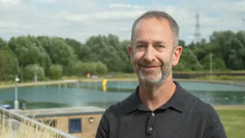 Jamie Niblock/BBC A portrait photo of Steve Bromberg with a lake in the background