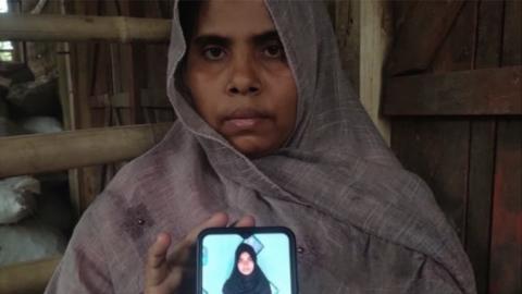 Sharifa Khatun cầm điện thoại cho thấy hình ảnh một thành viên trong gia đình bị mất tích