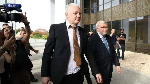 Getty Images WikiLeaks founder Julian Assange is joined by Kevin Rudd, Australian Ambassador to the U.S. as he arrives to the United States Courthouse where he is expected to enter a guilty plea to an espionage charge ahead of his expected release on June 26, 2024 in Saipan, Northern Mariana Islands