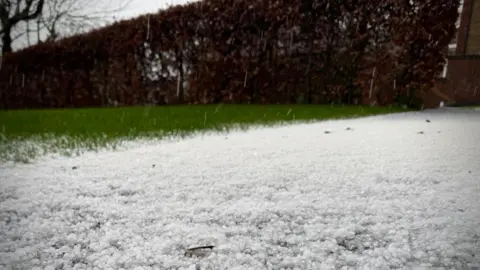 A dusting of hail covering a path.