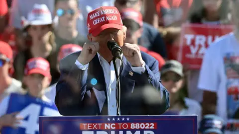 Getty Images Trump at lectern with fists up in front of seated supporters