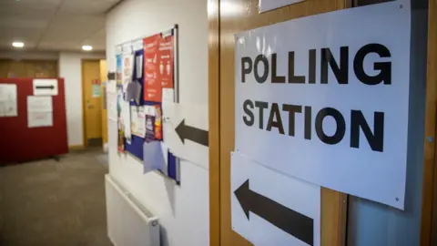 A sign which reads 'polling station' with an arrow pointing left at a polling station in south Belfast.