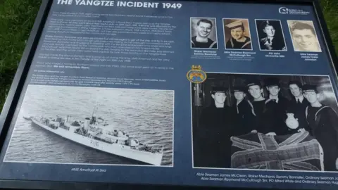 Andrew Bannister A blue storyboard with a picture of the ship and the sailors that were on it, including individual pictures of the sailors from Northern Ireland. 