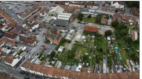 Lighthouse Development Consulting An aerial photograph of terraced houses with gardens backing onto a disused yard