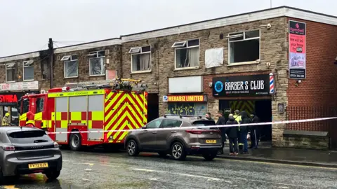 Alex Moss/BBC A photo from the scene which shows an empty window above a barber shop.