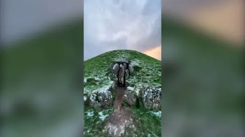 A passageway is seen beneath a hill