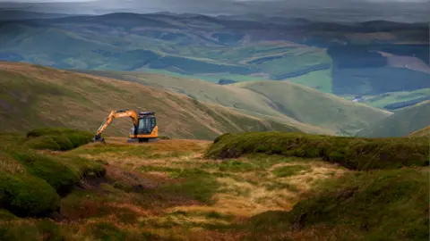 Northumberland National Park  A digger working on a remote hill 