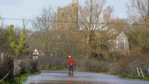 Aman looks at floodwater in Harbridge, Hampshire.