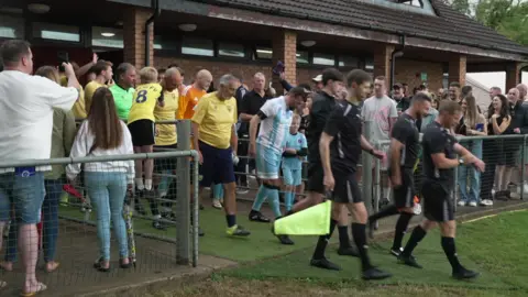 BBC The two teams walk out behind a team of officials.