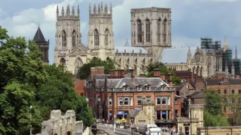 Concerns are being raised that the government's fair funding review could leave York 'the lowest funded' council in the country. This image is taken from York's city walls and captures York Minster surrounded by blue skies and clouds overlooking the landscape of York city centre across Lendal Bridge