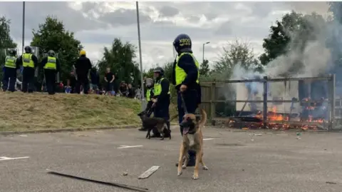 Oli Constable/BBC Police, police dog, crowd at the Holiday Inn in Manvers, Rotherham on 4 August