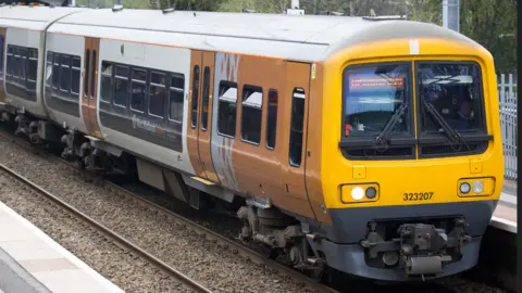 A West Midlands Railway train stopped at a station.