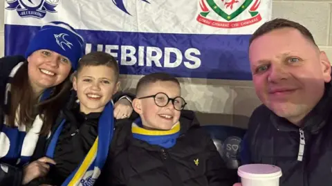 Family photo Ryder Goddard, his brother and parents David and Kirsty sat in the Cardiff City Stadium supporting their favourite team.