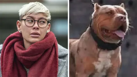 A woman with short blonde hair and glasses, wearing a grey court and red scarf and Cookie the dog