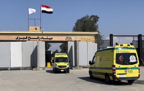 Ambulance cars pass the Rafah border crossing between the Gaza Strip and Egypt, in Rafah, Egypt