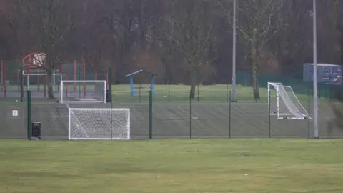 BBC Football pitch, with white goals and a green cage fencing around it