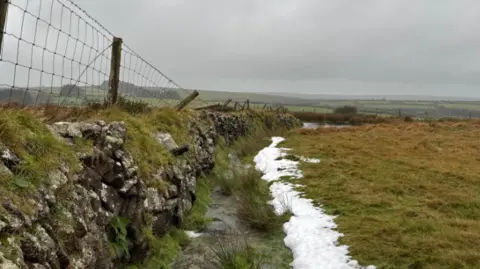 Cyril Stratus/BBC Weather Watchers St Breward with a bit of snow. Moorland and a stone wall pictured in gloomy conditions