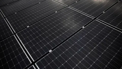 A view shows photovoltaic solar panels displayed on the roof of a building.