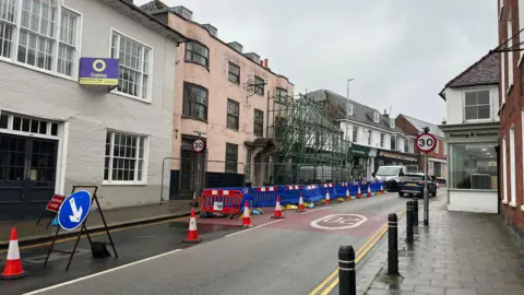 George Carden/BBC The scaffolding covers one side of the high street which is bordered by 18th and 19th century buildings.