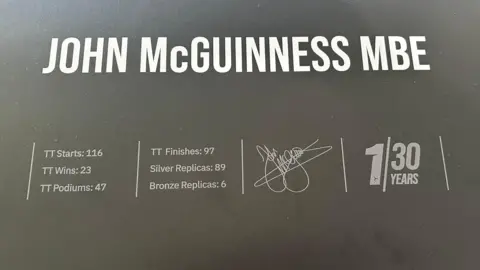 A board listing his 116 starts, 23 wins, 47 podium finishes, as well as the replicas won.