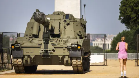 A woman running beside a military vehicle in Washington DC
