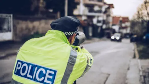 Getty Images A PSNI officer with a speeding gun pointed at an oncoming vehicle. 