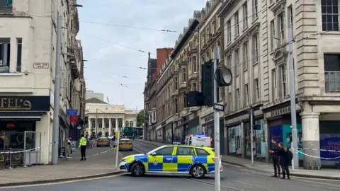 Police cars and a cordon in place in Market Steet, Nottingham