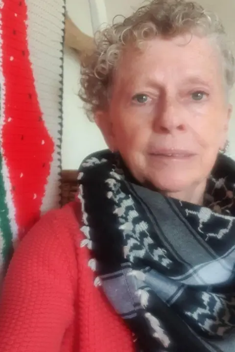 Dale Ryan Selfie photograph of Dee Murphy, who wears a black and white scarf and has short grey hair.