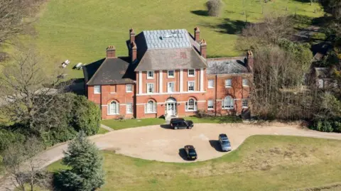 Heritage Images/Getty Images An aerial shot of Forest Lodge in Windsor Great Park, showing a large redbrick country manor house with pillars and cars parked out the front.