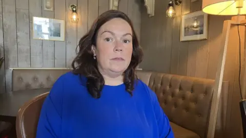 Colleen Dowdell, with long brown hair and blue top.