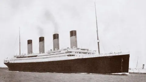 Getty Images A black and white photo of the Titanic, a large cruise linger with a black hull, two masts and four chimneys.