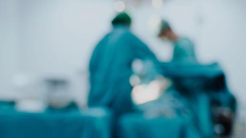 A blurred image of doctors performing surgery