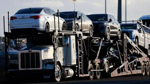 Vehicles are parked on car carrier trailers ready for distribution at a vehicle processing lot at the National City Marine Terminal, a major port for vehicle imports and exports, particularly for new foreign cars entering the United States on April 26, 2025 in National City, California