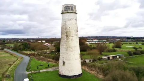 A wide angle shot of Leasowe Lighthouse with fields in the background