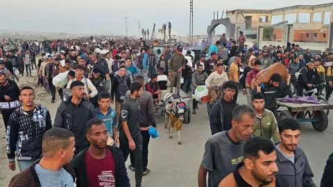 Displaced Palestinians return from a food distribution centre in Rafah, in the southern Gaza Strip, on 1 June 2025